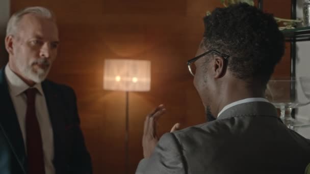 黑人男性企业家和他成熟的高加索商业伙伴肩并肩地在现代办公室里进行对话 — 图库视频影像