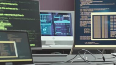 Gelişmiş program kodları gösteren üç masaüstü bilgisayarı olan ve siber güvenlik ajansındaki veri koruma sistemini izleyen hiç kimseyi görüntülemeyin.