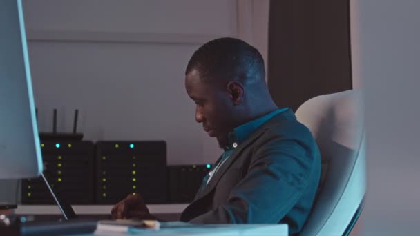 Geceleri Karanlık Sunucu Odasında Dizüstü Bilgisayarla Çalışan Genç Afrikalı Amerikan — Stok video