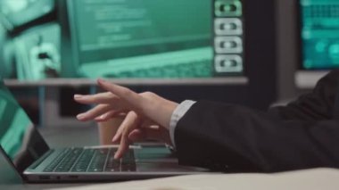 Geceleri sunucu odasındaki kapalı devre kameralarını izlerken bilgisayarın klavyesinde yazan tanınmayan kadın siber güvenlik görevlisinin el görüntüleri.