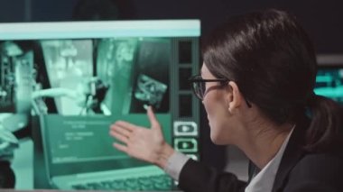 Sandık dolusu kadın siber güvenlik uzmanı meslektaşlarını güvenlik kameralarıyla sunucu odasında izlerken gece iş arkadaşlarıyla siber güvenlik ajansında çalışıyor.