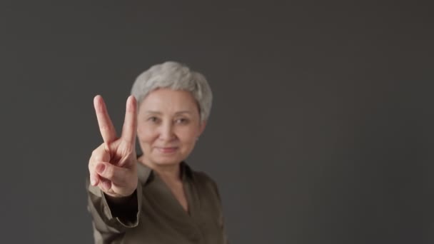 Medium Portrait Modern Senior Asian Woman Demonstrating Peace Sign Camera — Stock Video