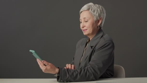 Περίμενε Μια Ηλικιωμένη Ασιάτισσα Κοντά Γκρίζα Μαλλιά Χαζεύει Στο Smartphone — Αρχείο Βίντεο
