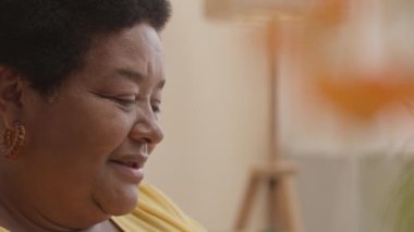 Mutlu Afrikalı Amerikalı son sınıf öğrencisinin evde kitap okurken çekilmiş yan görüntüsü.