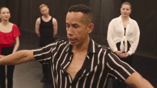 Medium Slowmo Latinamerikansk Manlig Danslärare Visar Latinska Dansrörelser För Grupp — Stockvideo