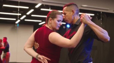 Stüdyoda şehvetli tango dansı yapan çok ırklı ve dışavurumcu genç dansçılar.