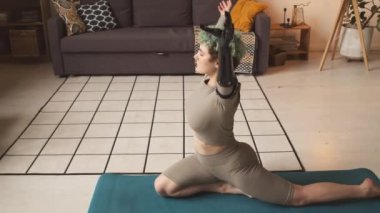 Biyonik kollu genç beyaz kadını yakınlaştır. Dua pozisyonu al ve meditasyon yap. Evdeki yoga minderinde uzan.