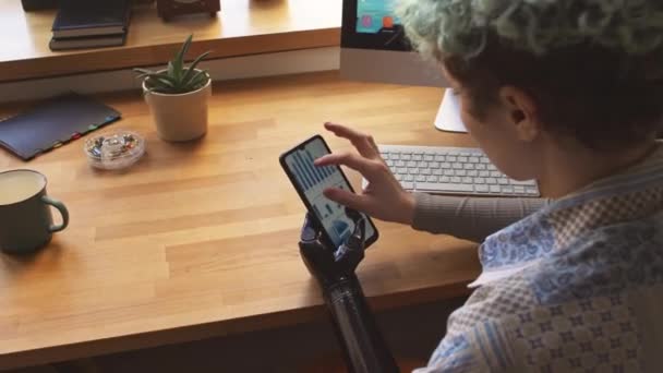 Kıvırcık Saçlı Serbest Çalışan Protez Kollu Akıllı Telefon Ekranında Grafiğini — Stok video