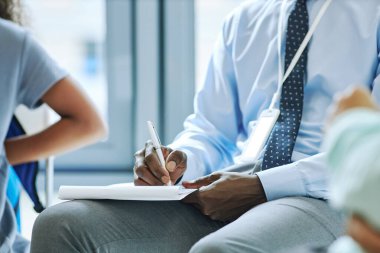 Tanımlanamayan erkek terapistin seans sırasında destek grubuyla not alıp, boşluğu kopyaladığı