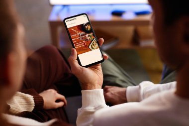 Genç çiftin evde otururken internetten yemek siparişi vermeleri.