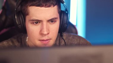 Karanlık siber spor kulübünde, kulaklık takmış, internetten bilgisayar oyunu oynayan oyuncular yavaşlıyor.