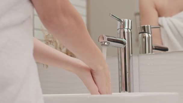 穿着白色毛巾在浴室洗澡间洗手的无法辨认的年轻女子的倒影镜头 — 图库视频影像