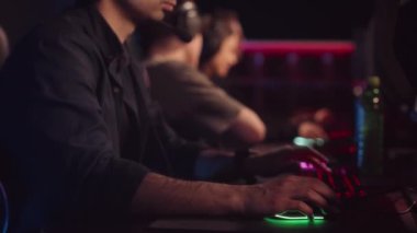 Karanlık esportlar kulübünde bilgisayar başında oynayan oyuncular yavaşlıyor.