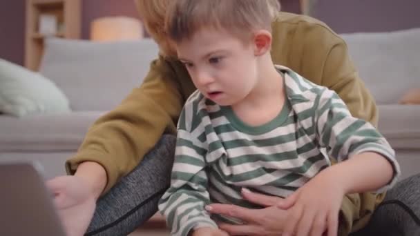 Річний Хлопчик Синдромом Дауна Дивиться Ноутбук Комп Ютера Проводячи Час — стокове відео