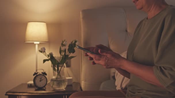 Старшая Азиатка Заканчивает Просмотр Смартфоне Выключает Свет Ложится Спать Ночью — стоковое видео