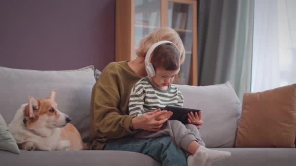 Kaukasischer Kleiner Junge Mit Syndrom Spielt Spiele Auf Dem Smartphone — Stockvideo