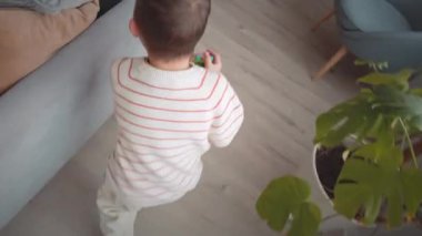 Boş zamanlarında annesiyle evde oynarken oturma odasında koşuşturan Kafkasyalı küçük çocuğun el bilgisayarı.
