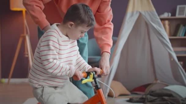 Річний Кавказький Хлопчик Синдромом Дауна Вчиться Їздити Велосипеді Мамою Вдома — стокове відео