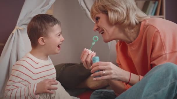 Счастливый Маленький Мальчик Синдромом Дауна Любимая Мама Пускают Мыльные Пузыри — стоковое видео