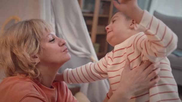 Медленно Любящая Мать Целует Своего Маленького Сына Синдромом Дауна Носу — стоковое видео