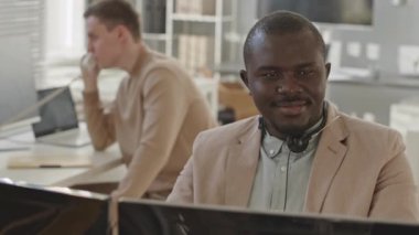 Kafkas meslektaşı ile güvenlik teşkilatında çalışırken bilgisayar monitörüne bakan siyahi adam yavaşlıyor.