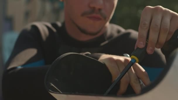 白种人年轻轮椅手在室外修理自适应软板时使用螺丝刀的中等特写 — 图库视频影像