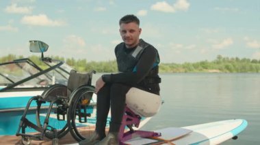 Kafkasyalı engelli bir gencin portresi. Güneşli bir günde kameraya gülümsüyor.