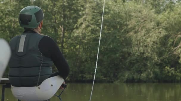 在温暖的阳光明媚的日子里 一个没有腿的少年在河里练习用绳索进行适应性滑行的背景图 — 图库视频影像
