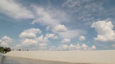 Ayakları olmayan genç sörfçü yazın açık havada uyarlanabilir uyanış egzersizi yaparken kaydırma hareketleriyle profesyonel numaralar yapıyor.