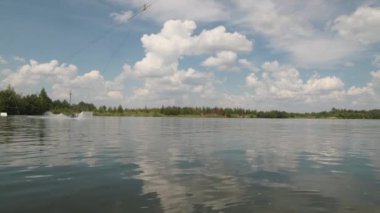 Ampüte olmuş bacakları olan genç bir adam yaz mevsiminde açık havada sörf yapmayı öğreniyor.