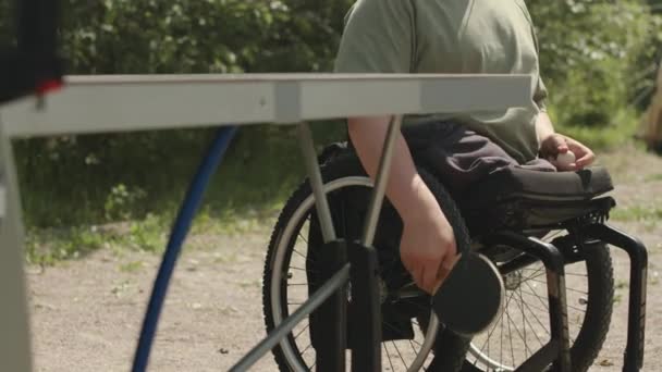 夏に屋外でテニスをする車椅子に足がないコーカサス州の十代の少年の中程度のスローモ — ストック動画
