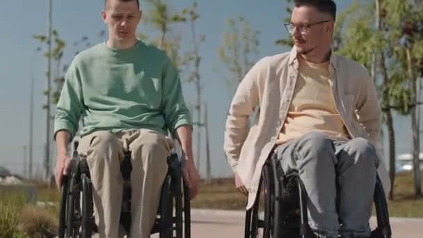 Yazın Kaldırım Boyunca Tekerlekli Sandalyeyle Gezen Iki Beyaz Erkek Arkadaşı — Stok video