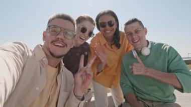 İki genç ve mutlu tekerlekli sandalyeli adamın el bilgisayarı. Sevgilileriyle birlikte yazın dışarıda takılırken kameraya kayıttalar.