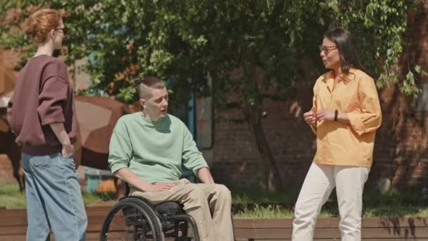 Νεαρός Καυκάσιος Άνδρας Αναπηρική Καρέκλα Συνομιλεί Δύο Ελκυστικές Γυναίκες Φίλους — Αρχείο Βίντεο