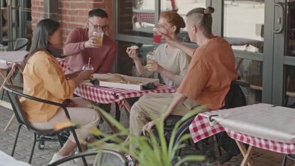 Grupa Młodych Zróżnicowanych Ludzi Siedzi Przy Stole Kawiarni Letniej Świeżym — Wideo stockowe