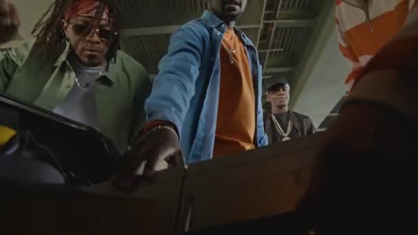 Afrikalı Amerikalı Beyaz Arkadaşları Arabanın Bagajından Müzik Setini Indirip Otoparkta — Stok video