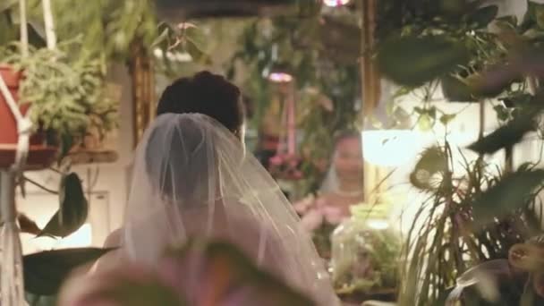 식물에서 결혼식을 신부와 우아한 드레스와 베일을 Biracial 신부의 뒤보기 — 비디오