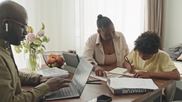 Mediana Toma Joven Mujer Negra Ayudando Hijo Preadolescente Con Tarea — Vídeo de stock