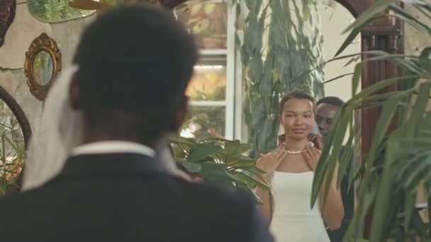 Uzun Boylu Aynanın Önünde Duran Mutlu Siyah Düğün Kostümlü Genç — Stok video