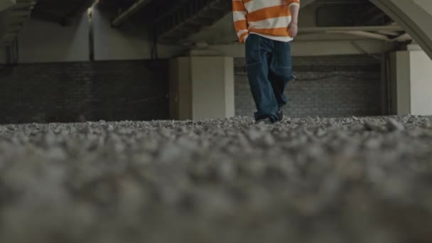身着蓝色宽松牛仔裤 条纹超大运动衫 朝城市桥下的摄像头走去的难以辨认的家伙的剪影 — 图库视频影像