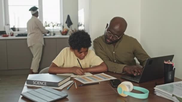 Waist Black Man Hilft Seinem Preteen Sohn Bei Den Hausaufgaben — Stockvideo
