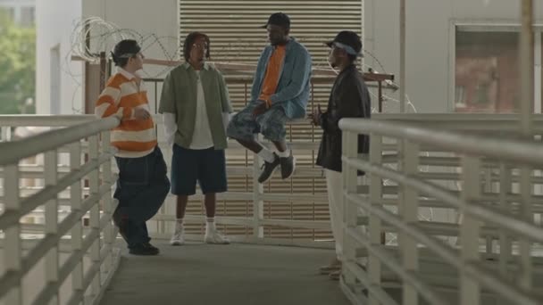 全长拍摄的多种族嘻哈乐队 穿着旧式校服 在街上抽烟和说话 — 图库视频影像