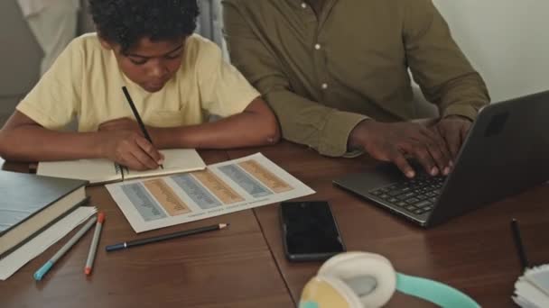 Naklonit Afroameričan Muž Pomáhá Jeho Základní Věk Syn Domácím Úkolem — Stock video