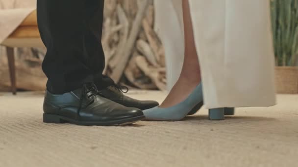 婚礼期间 新郎和新娘站在地板上 双腿低矮 难以辨认 新娘踮起脚尖吻她的新郎 — 图库视频影像