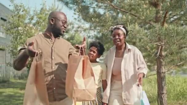 여름에 아프리카계 가족의 엄마와 아빠는 가방을 들고있는 그들의 아들과 이야기 — 비디오