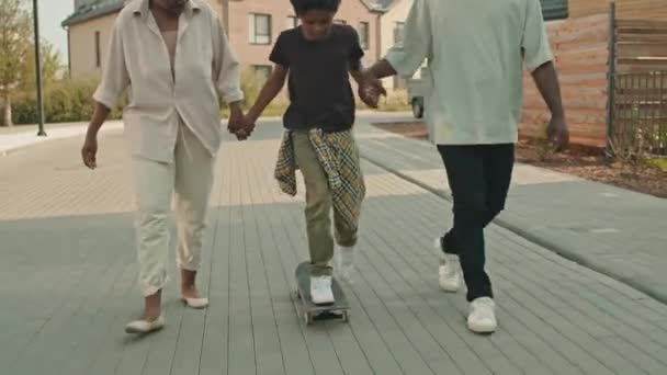 Afroameričtí Moderní Rodiče Pomáhá Jejich Předpubertální Syn Jezdit Skateboardu Ulici — Stock video