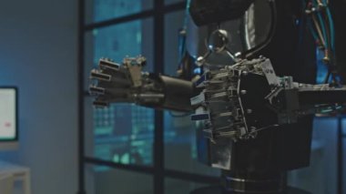 Yapay zeka robotunun karanlık elektronik laboratuarında sıkışık metal ellerinin orta bölüm çekimi.
