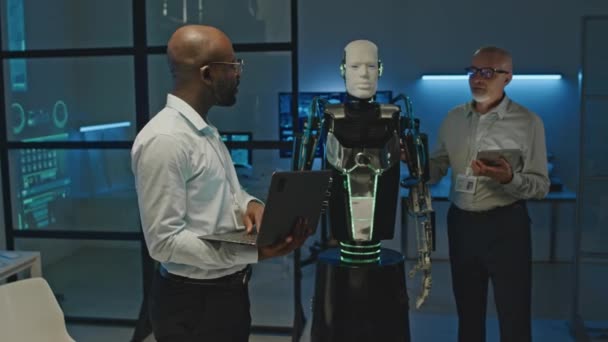 실험실에서 일하는 인간형 로봇의 활성화를 논의하는 엔지니어의 — 비디오