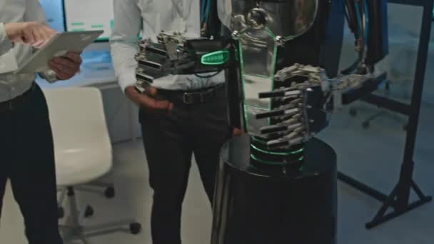 실험실에서 인간형 로봇을 작동하는 디지털 태블릿을 사용하여 다인종 개발자의 기울이십시오 — 비디오