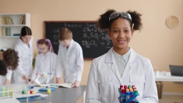 Mittleres Porträt Eines Afroamerikanischen Schulmädchens Weißen Laborkittel Mit Reagenzgläsern Regal — Stockvideo